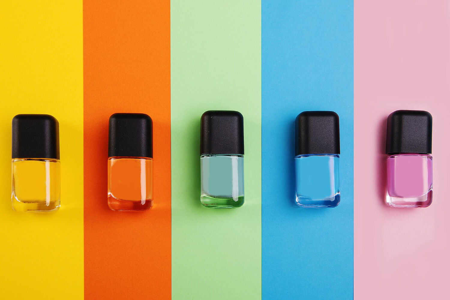 top-view-nail-polish-bottles-different-shades-colorful-surface
