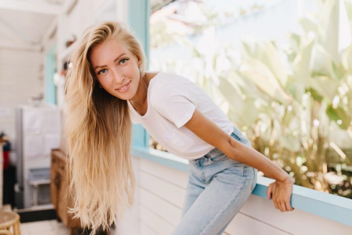 Graceful lady with long blonde hair having fun in weekend and po