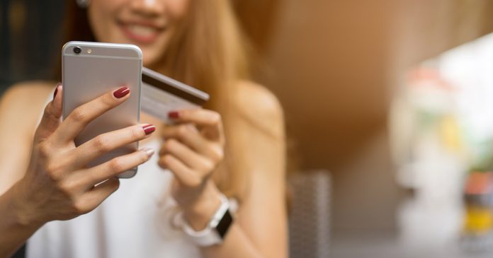 close up asian business woman holding smartphone with credit car Kobieta dodaje kartę do aplikacji mobilnej