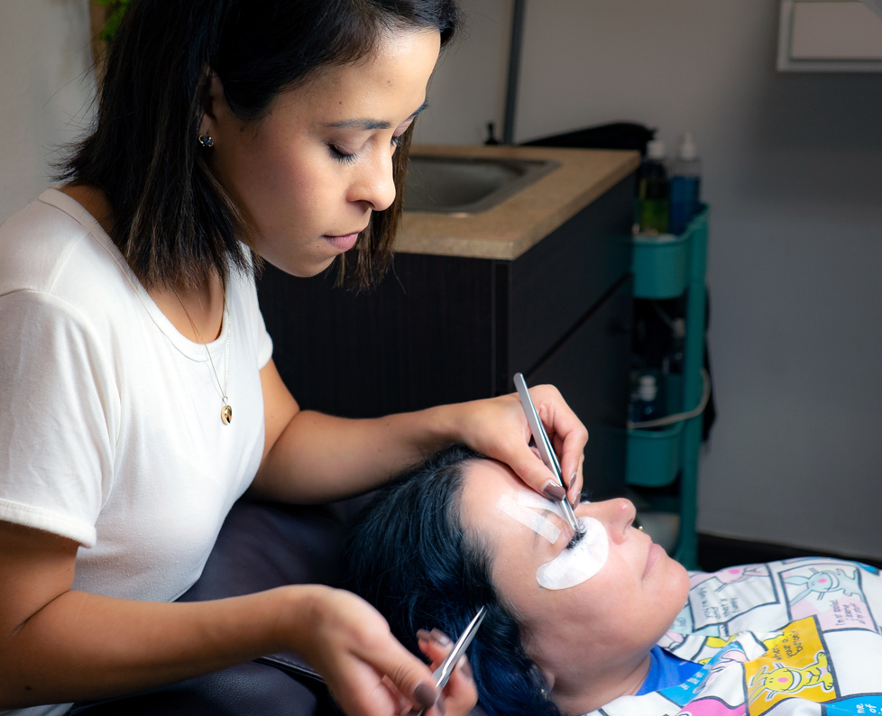Maya applying eyelashes to a client.