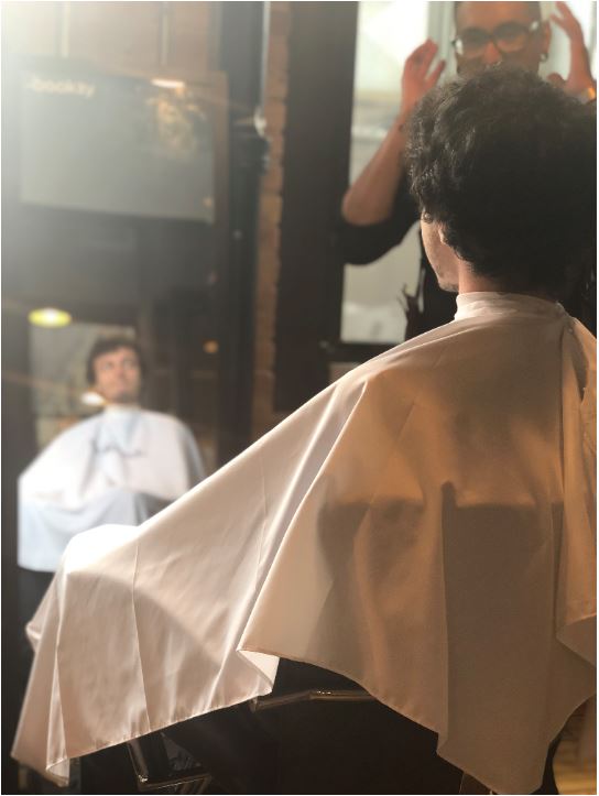 client looking into mirror with barber