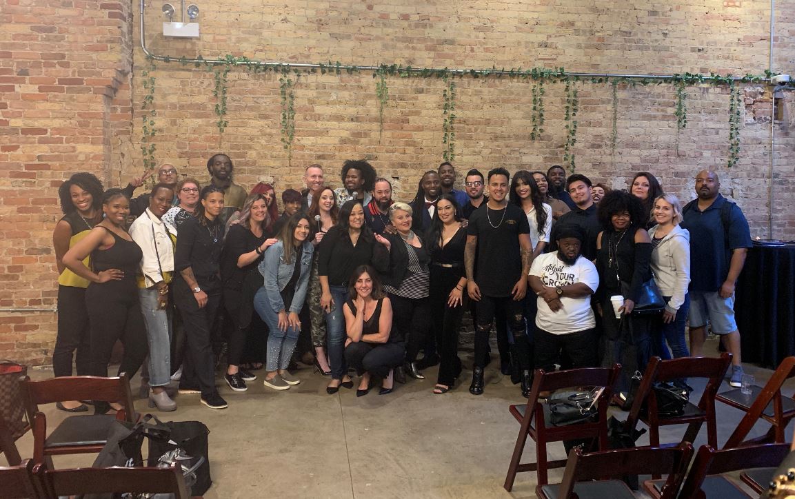 group photo of people in front of a brick wall