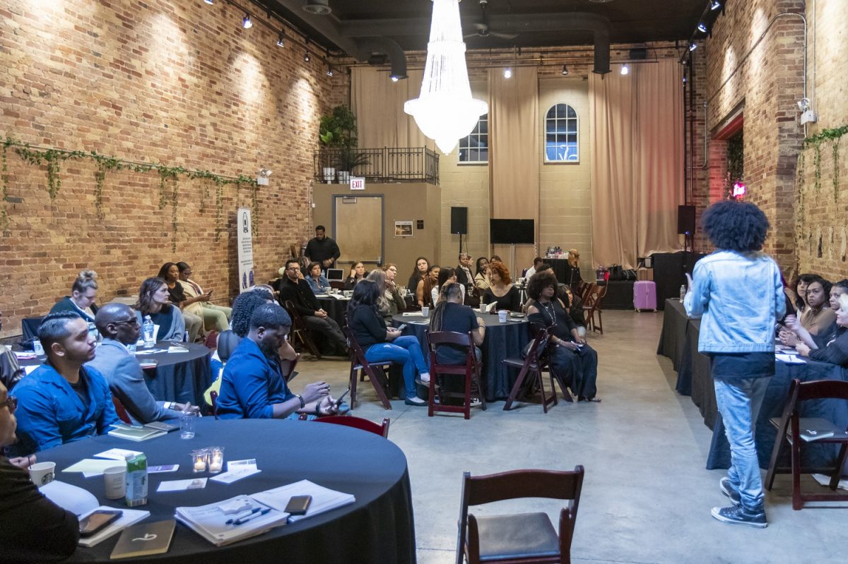 open room with hanging chandelier filled with attendees